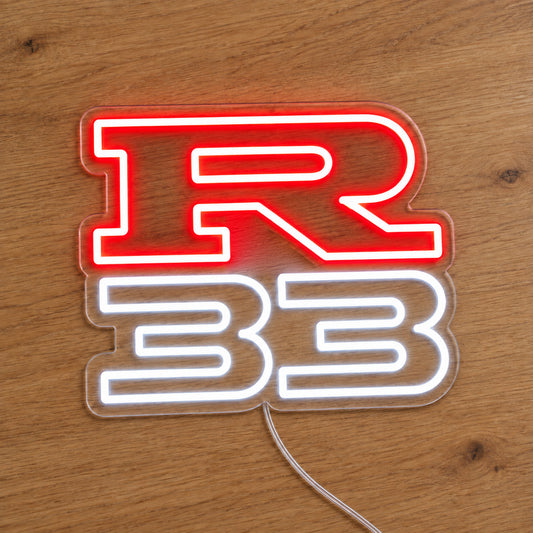 Nissan R33 LED Neon Sign in red and white, featuring R33 lettering on a wooden surface.