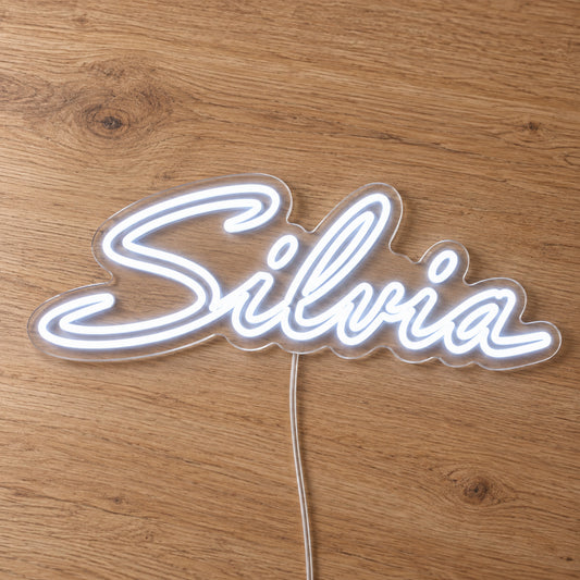 Nissan Silvia LED Neon Sign in white, featuring Silvia script lettering on a wooden surface, close-up view.