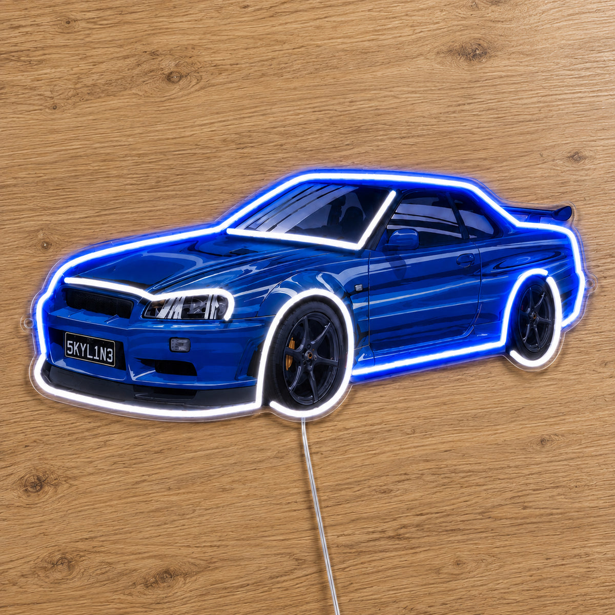 Nissan Skyline R34 LED Neon Sign in blue and white, featuring Nissan Skyline R34 car design on a wooden surface.