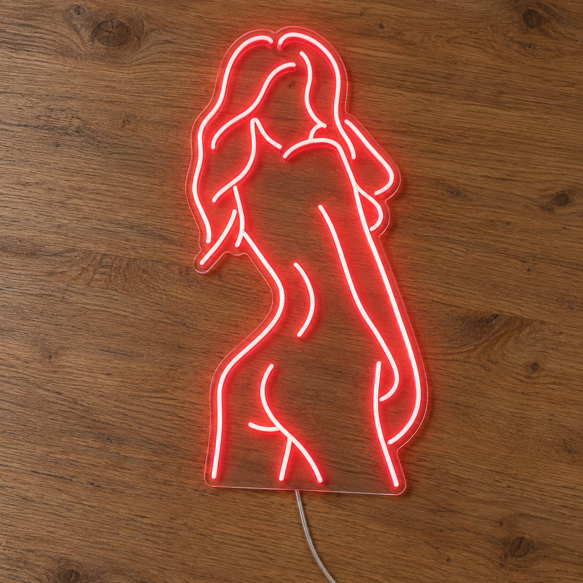 Nude Woman LED Neon Sign in red, featuring outline of a woman's figure on a wooden surface.