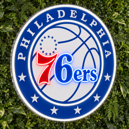 Philadelphia 76ers LED Neon Sign, featuring illuminated team logo on a green foliage wall.