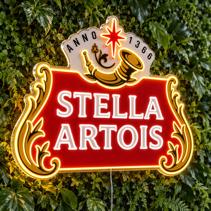 Stella Artois LED Neon Sign, featuring beer-brand logo displayed on a green foliage wall.