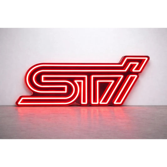 Subaru STI Neon Sign in red, featuring STI logo lettering against a light wall.