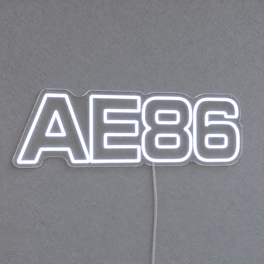 Toyota AE86 LED Neon Sign in white, featuring AE86 lettering on a grey wall.