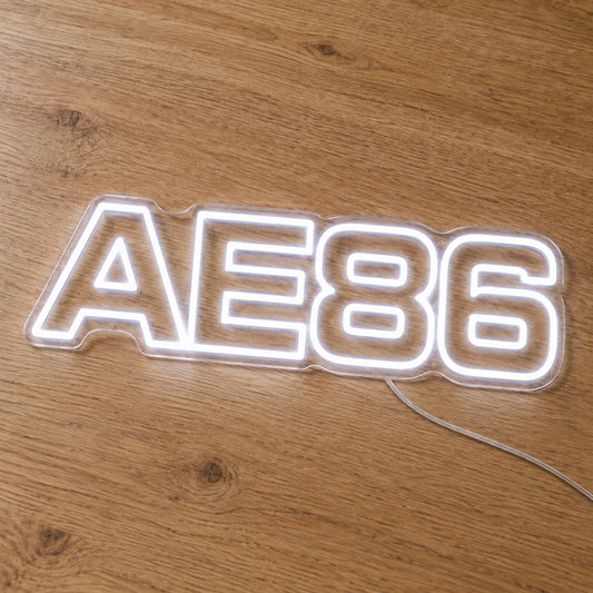 Toyota AE86 LED Neon Sign in white, featuring AE86 lettering on a wooden surface.