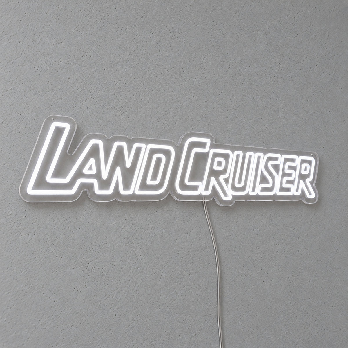 Toyota Land Cruiser LED Neon Sign in white, featuring Land Cruiser lettering on a grey wall.