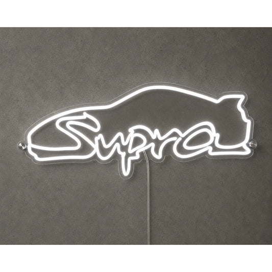 Toyota Supra Neon Sign in white, featuring Supra script logo with a car-roof outline on a grey wall.