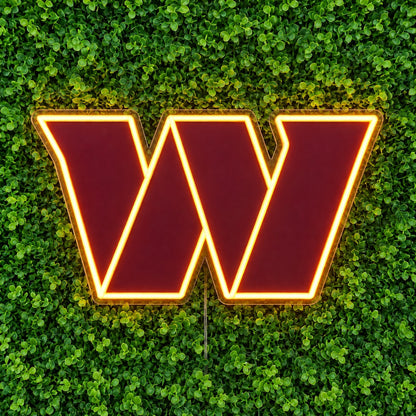 Washington Commanders LED Neon Sign, featuring illuminated team logo on a green foliage wall.