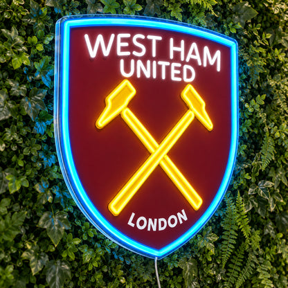West Ham United LED Neon Sign, featuring team logo displayed on a green foliage wall.
