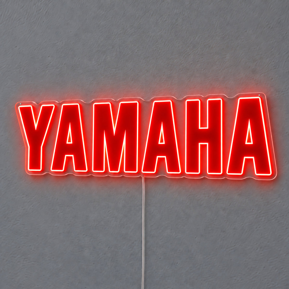 Yamaha (Red) LED Neon Sign in red, featuring Yamaha lettering on a grey wall.