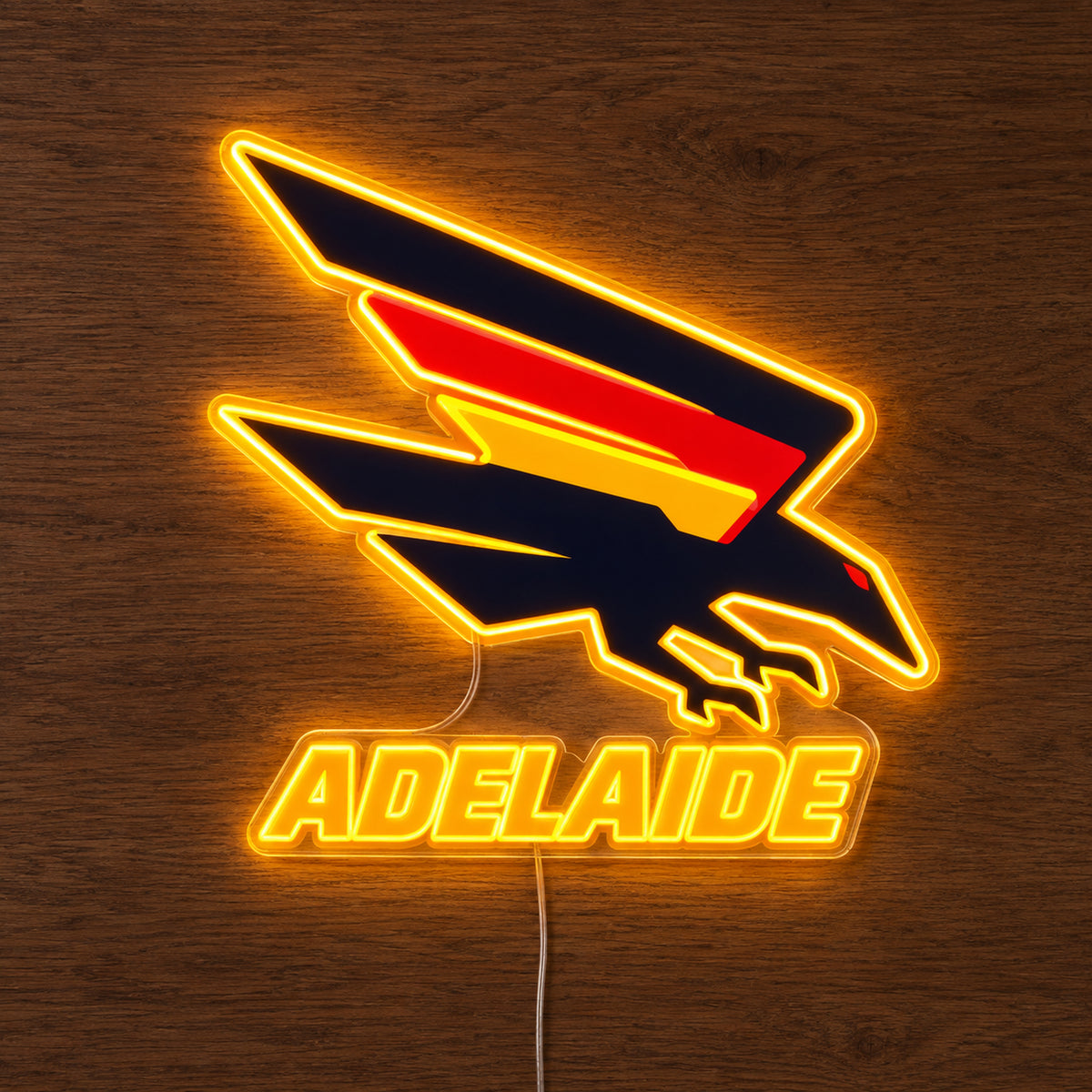 Adelaide Crows neon sign glowing brightly on a wooden surface in dim lighting