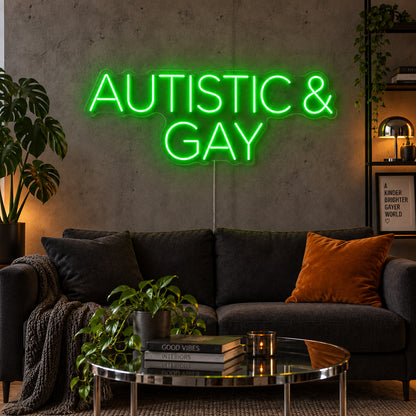 Autistic & Gay Neon Sign with green lighting, displayed above a dark sofa against a concrete wall.