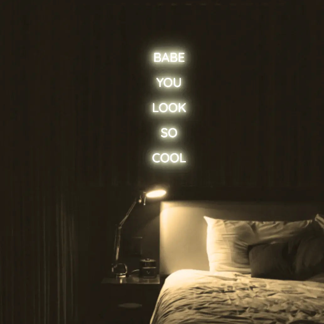 Babe You Look So Cool 2 LED Neon Light Sign in warm white, featuring five stacked words illuminated above a bed.