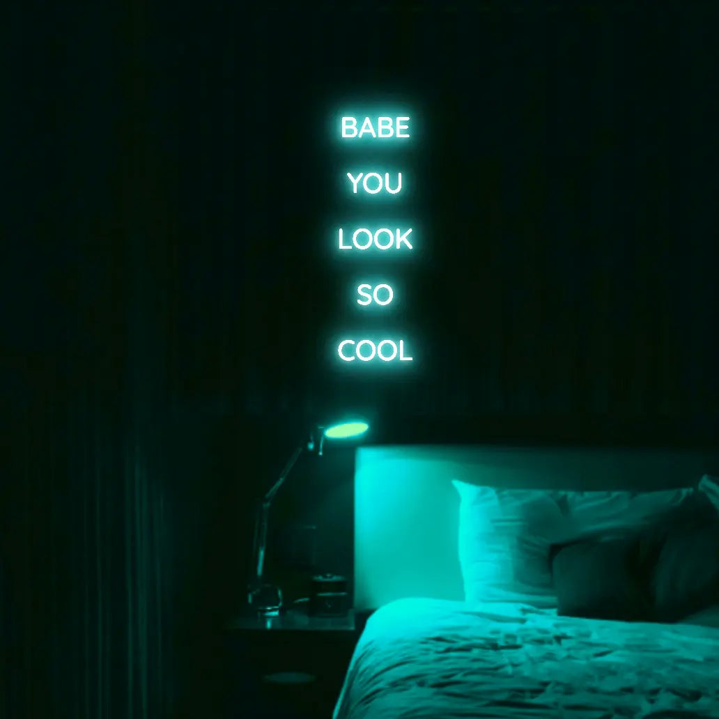 Babe You Look So Cool 2 LED Neon Light Sign in turquoise, featuring five stacked words illuminated above a bed.