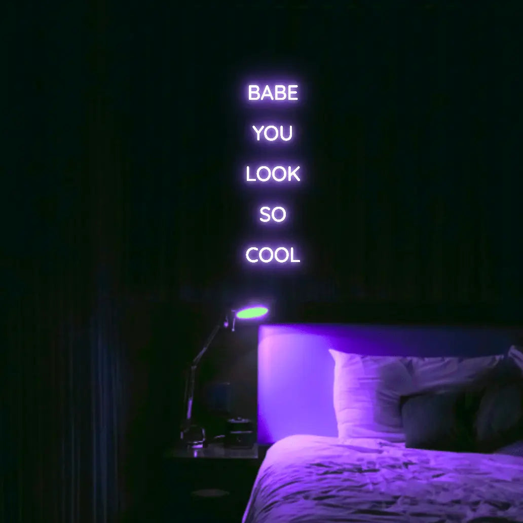 Babe You Look So Cool 2 LED Neon Light Sign in purple, featuring five stacked words illuminated above a bed.