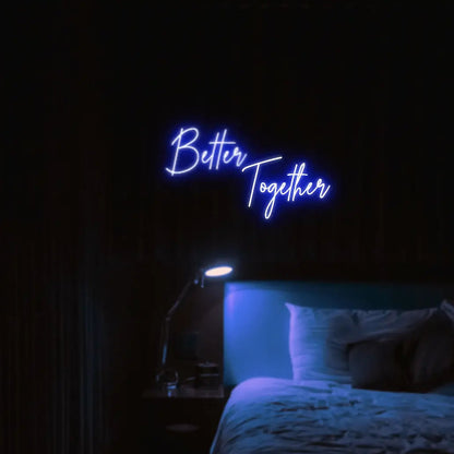 Better Together LED Neon Light Sign in blue, featuring two lines of script lettering illuminated above a bed.