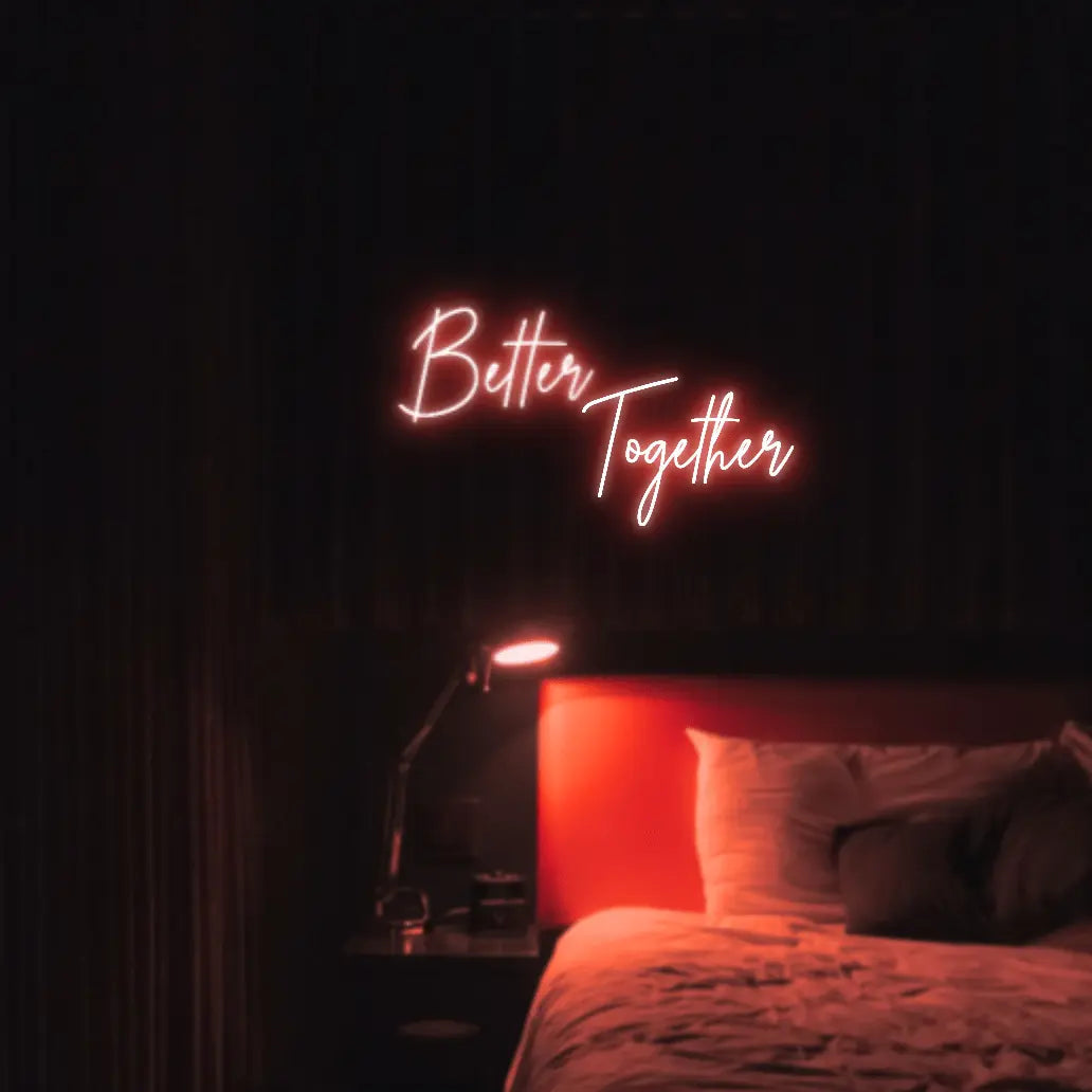 Better Together LED Neon Light Sign in red, featuring two lines of script lettering illuminated above a bed.