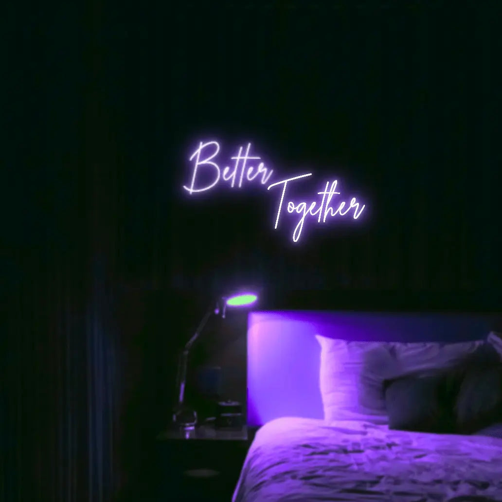 Better Together LED Neon Light Sign in purple, featuring two lines of script lettering illuminated above a bed.