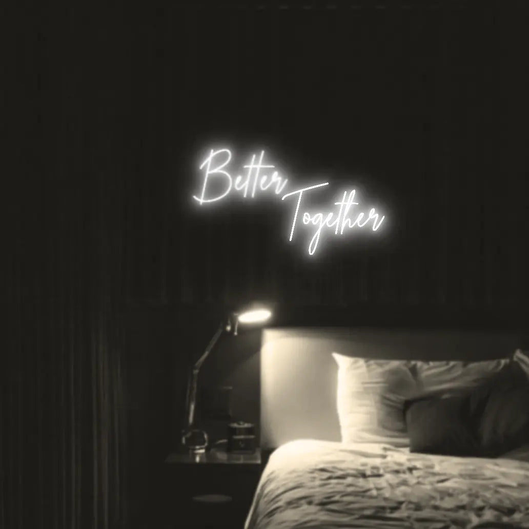Better Together LED Neon Light Sign in white, featuring two lines of script lettering illuminated above a bed.