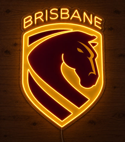 Brisbane Broncos Neon Sign, featuring illuminated team logo on a wooden surface in dim lighting.