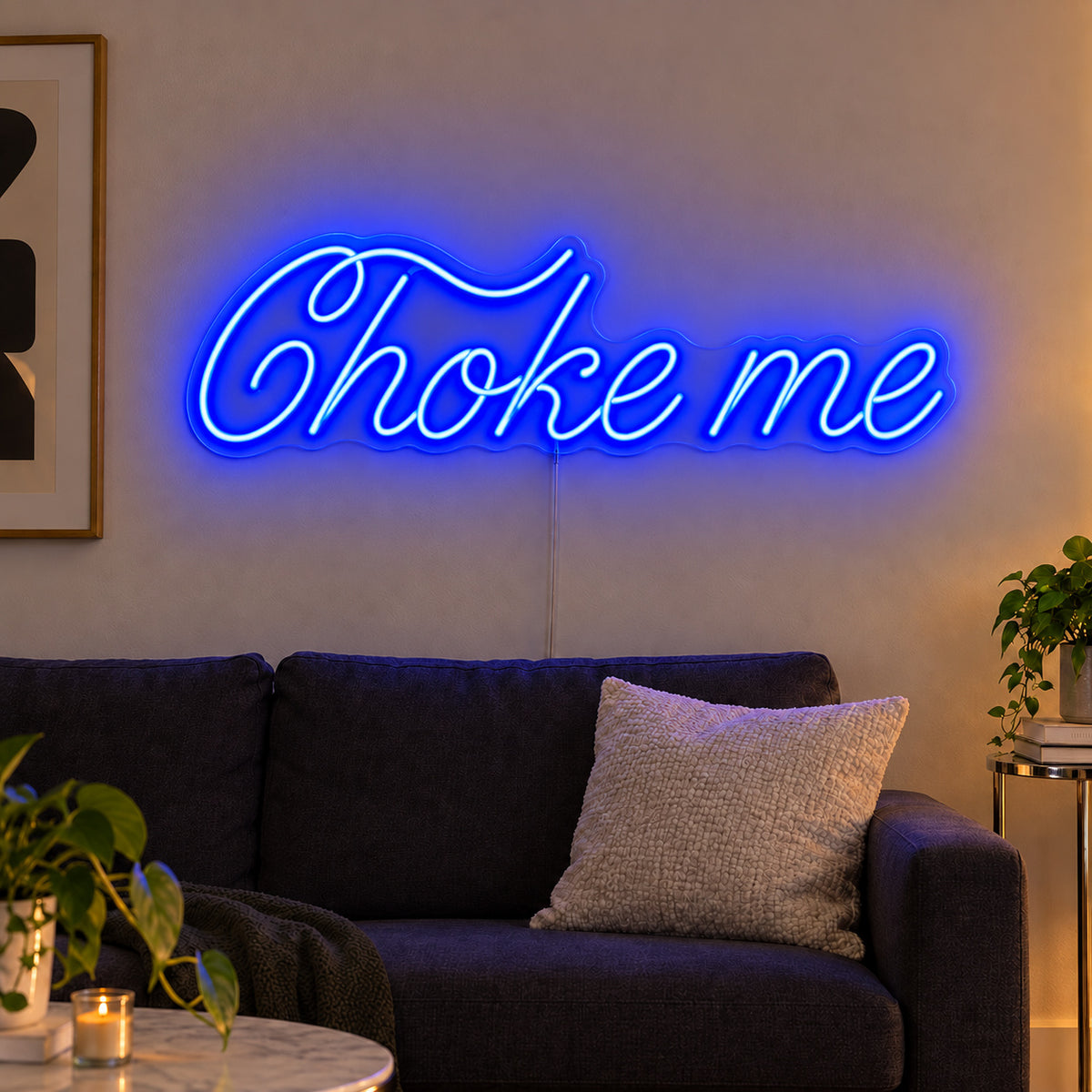 Choke Me Neon Sign in blue, featuring Choke Me script lettering above a dark sofa.