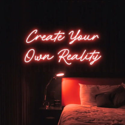 Create Your Own Reality LED Neon Light Sign in red, featuring two lines of script lettering illuminated above a bed.