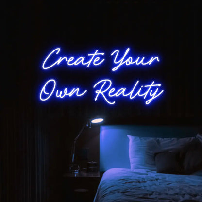 Create Your Own Reality LED Neon Light Sign in blue, featuring two lines of script lettering illuminated above a bed.