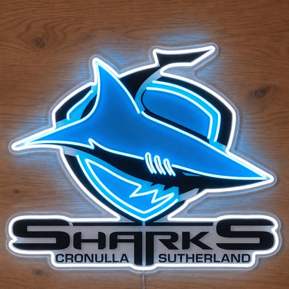 Cronulla Sharks Neon Sign, featuring illuminated team logo on a wooden surface.