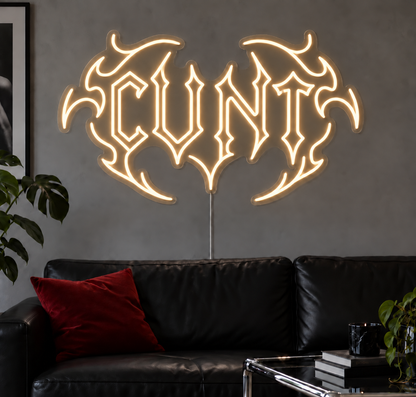 Cunt Neon Sign in Warm White LED neon with double outlined C, displayed above a black leather sofa.