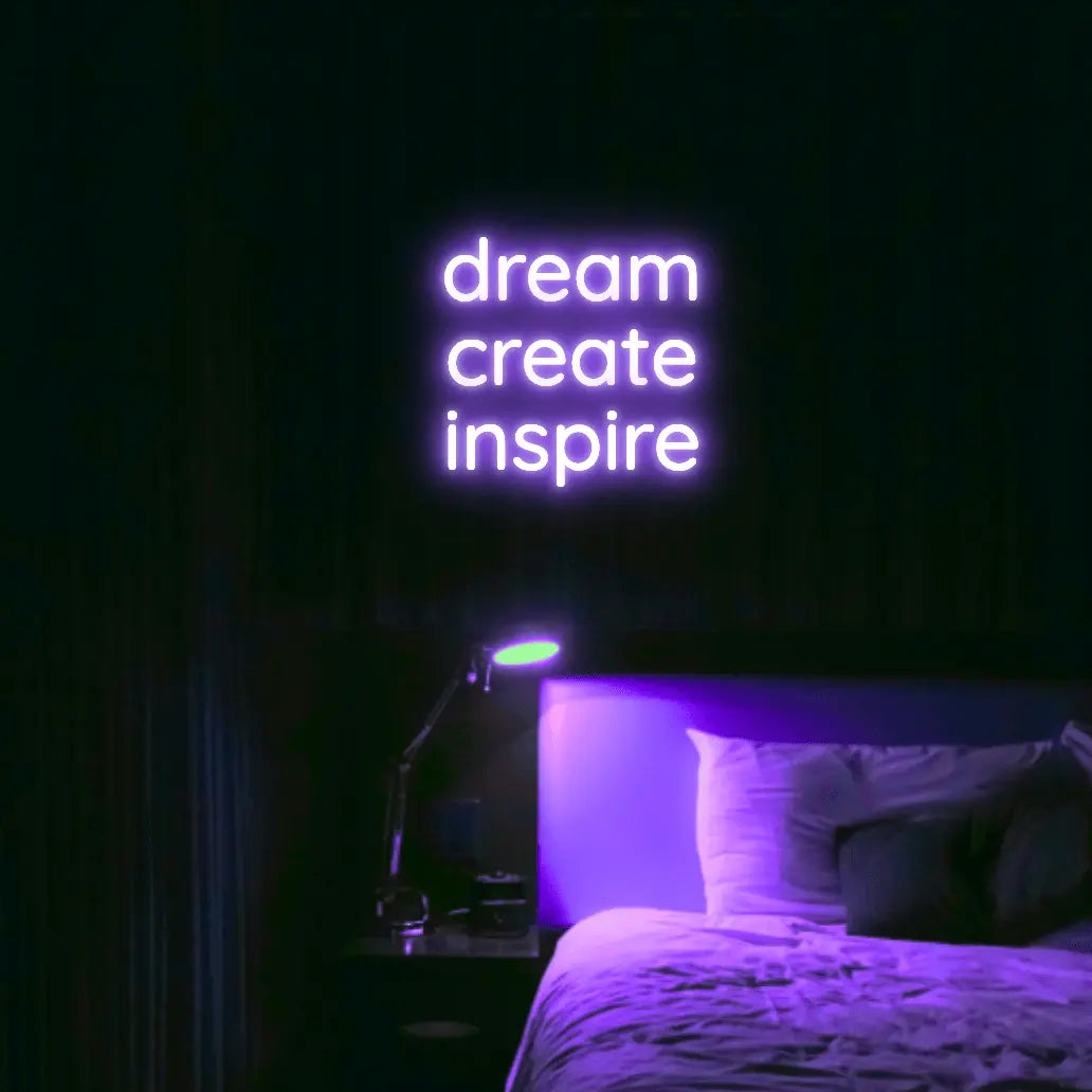 Dream Create Inspire LED Neon Light Sign in purple, featuring three lines of lettering illuminated above a bed.
