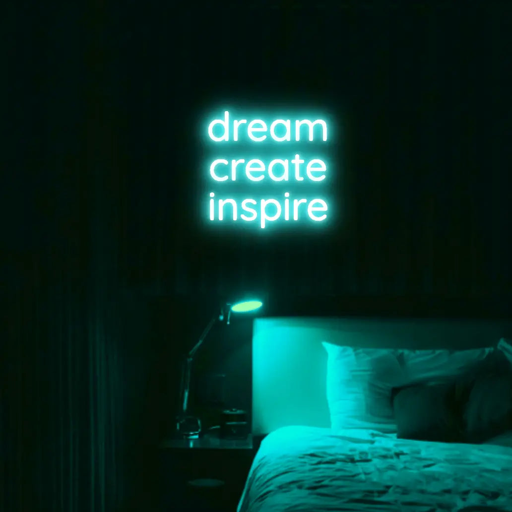 Dream Create Inspire LED Neon Light Sign in turquoise, featuring three lines of lettering illuminated above a bed.