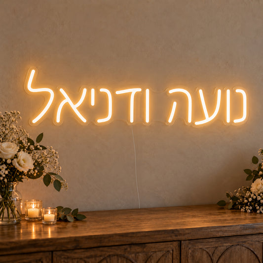 Personalised Hebrew Couple Names Neon Sign on clear cut-to-shape acrylic in an illuminated wall display; example personalisation shown.