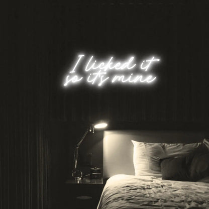 I Licked It So Its Mine LED Neon Light Sign in white, featuring two lines of script lettering illuminated above a bed.