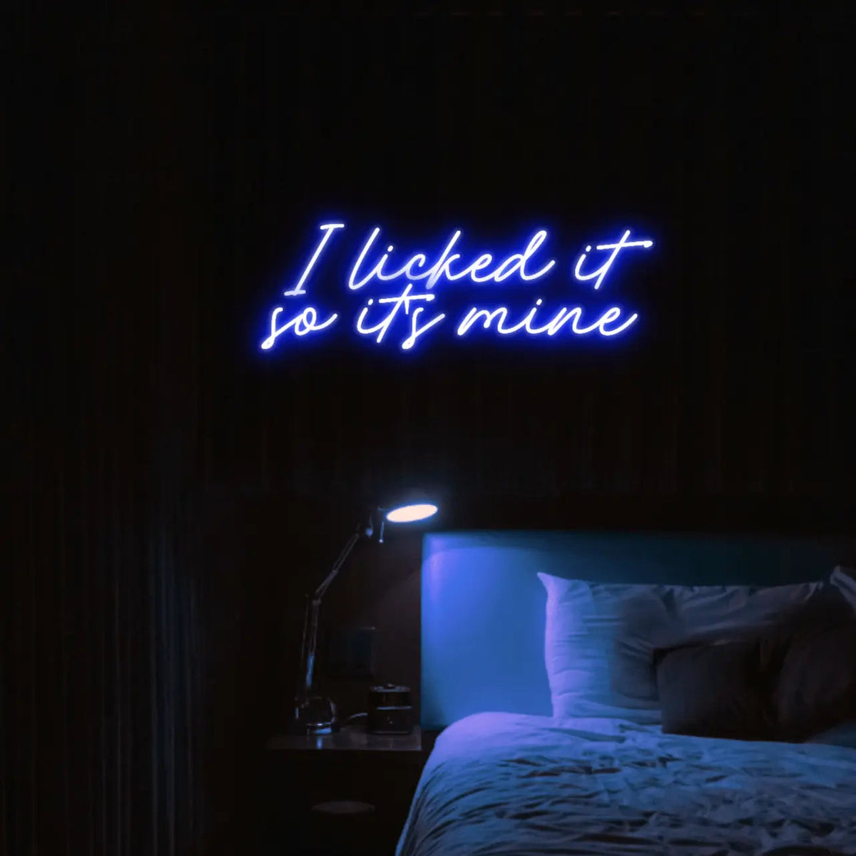 I Licked It So Its Mine LED Neon Light Sign in blue, featuring two lines of script lettering illuminated above a bed.