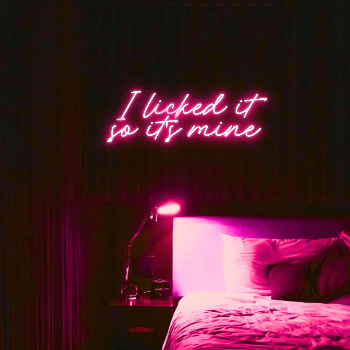 I Licked It So Its Mine LED Neon Light Sign in pink, featuring two lines of script lettering illuminated above a bed.