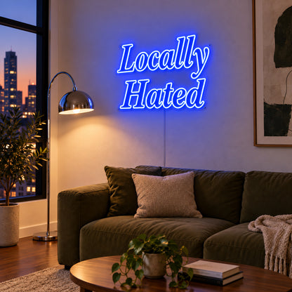 Locally Hated Neon Sign in blue, featuring two lines of decorative Locally Hated lettering above a green sofa.