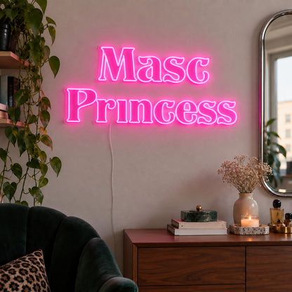 Masc Princess Neon Sign glowing pink above a wooden sideboard beside a green chair.