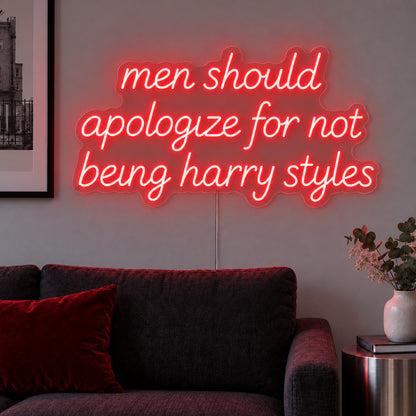 Men Should Apologize For Not Being Harry Styles Neon Sign with red lighting, displayed above a dark sofa.