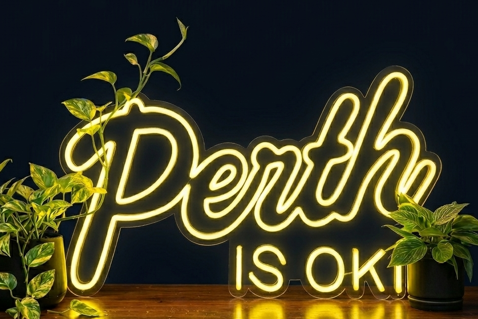 Perth is OK! neon sign on a dark background with plants, shown as custom sign inspiration for Cottesloe.
