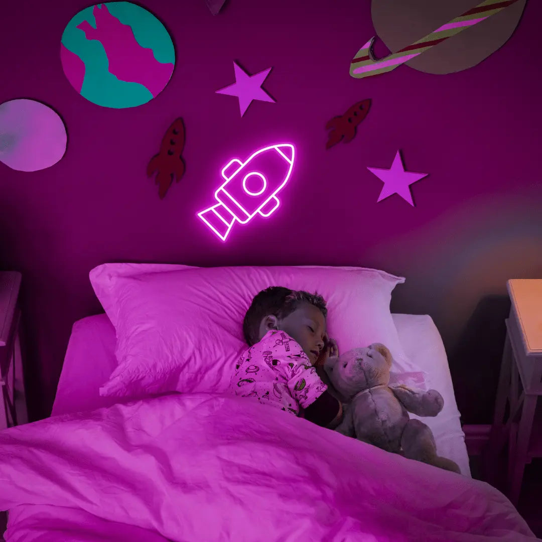 Rocket LED Neon Light Sign in pink, featuring rocket outline illuminated on a space-themed bedroom wall.