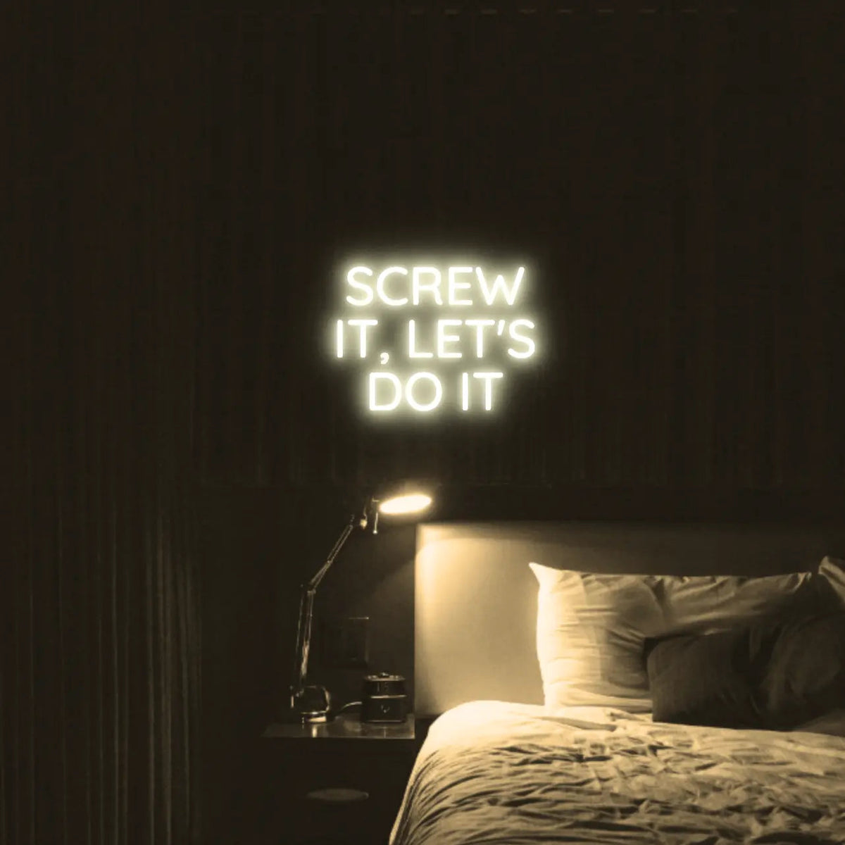 Screw It, Let's Do It LED Neon Light Sign in warm white, featuring stacked block lettering illuminated above a bed.