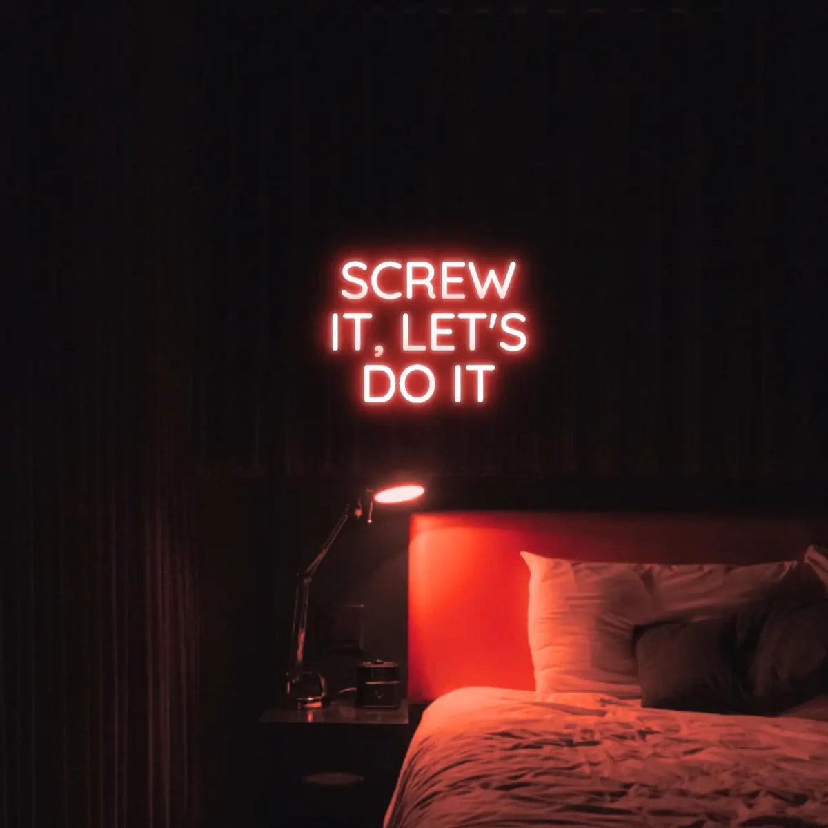 Screw It, Let's Do It LED Neon Light Sign in red, featuring stacked block lettering illuminated above a bed.
