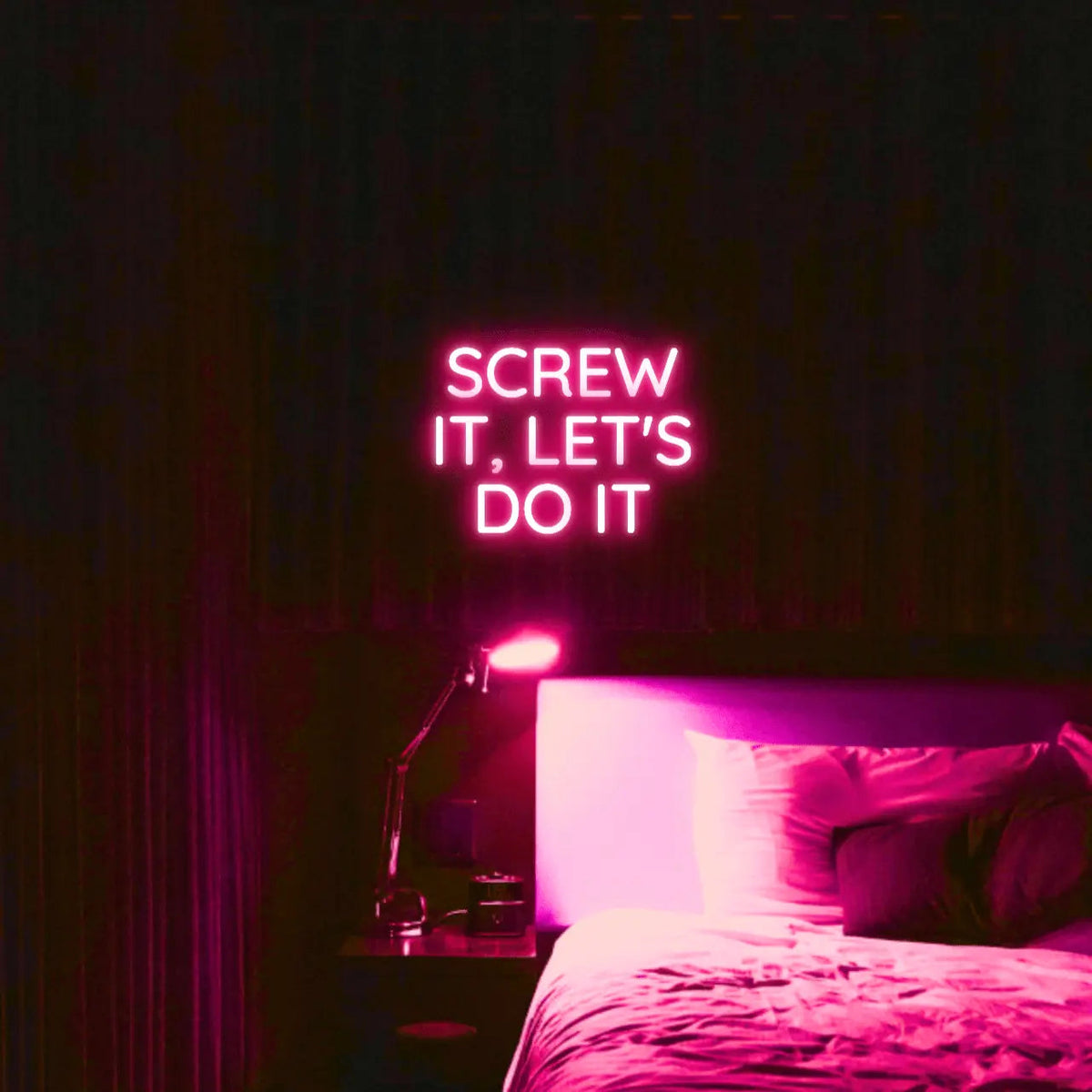 Screw It, Let's Do It LED Neon Light Sign in pink, featuring stacked block lettering illuminated above a bed.
