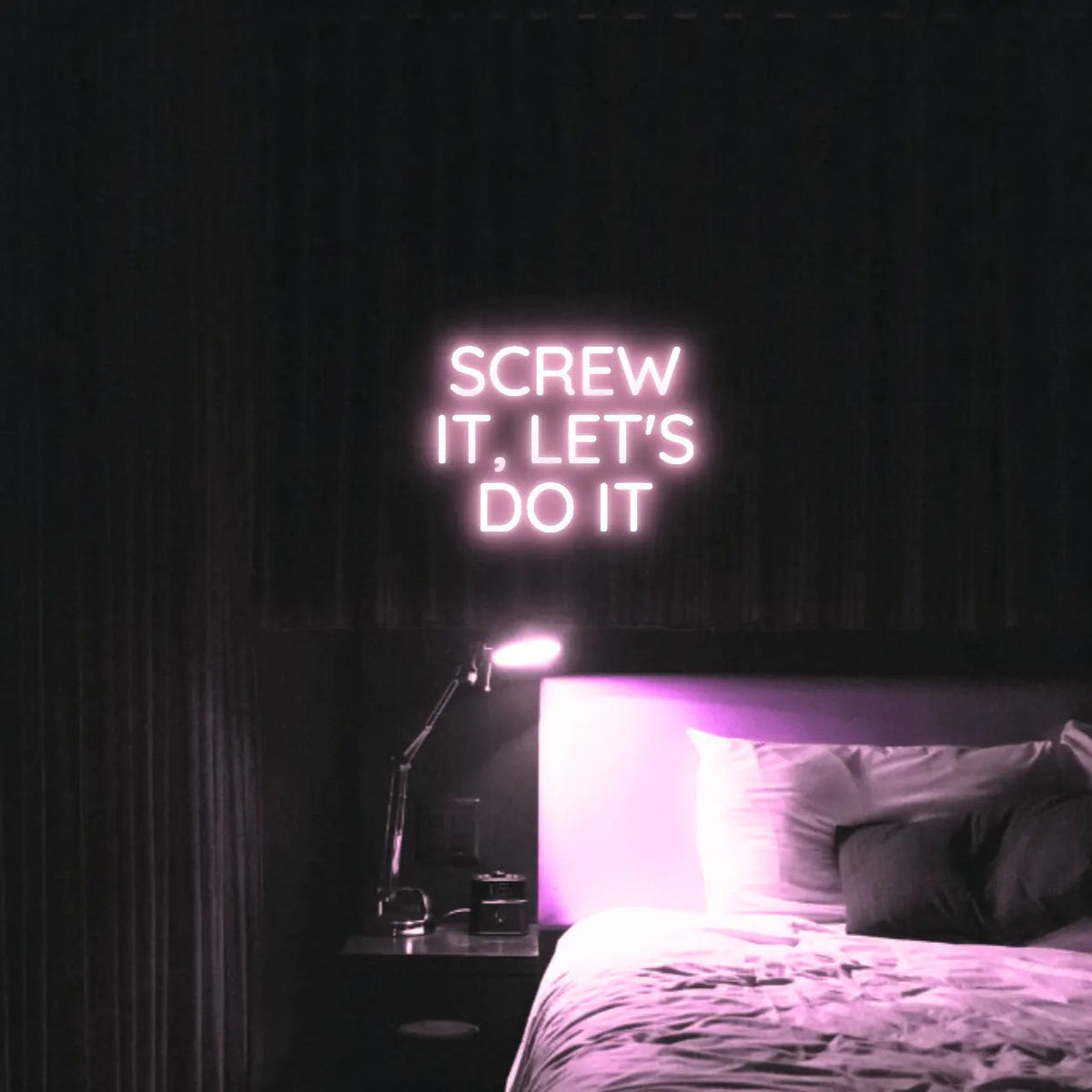 Screw It, Let's Do It LED Neon Light Sign in pale pink, featuring stacked block lettering illuminated above a bed.
