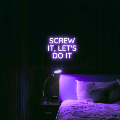 Screw It, Let's Do It LED Neon Light Sign in purple, featuring stacked block lettering illuminated above a bed.