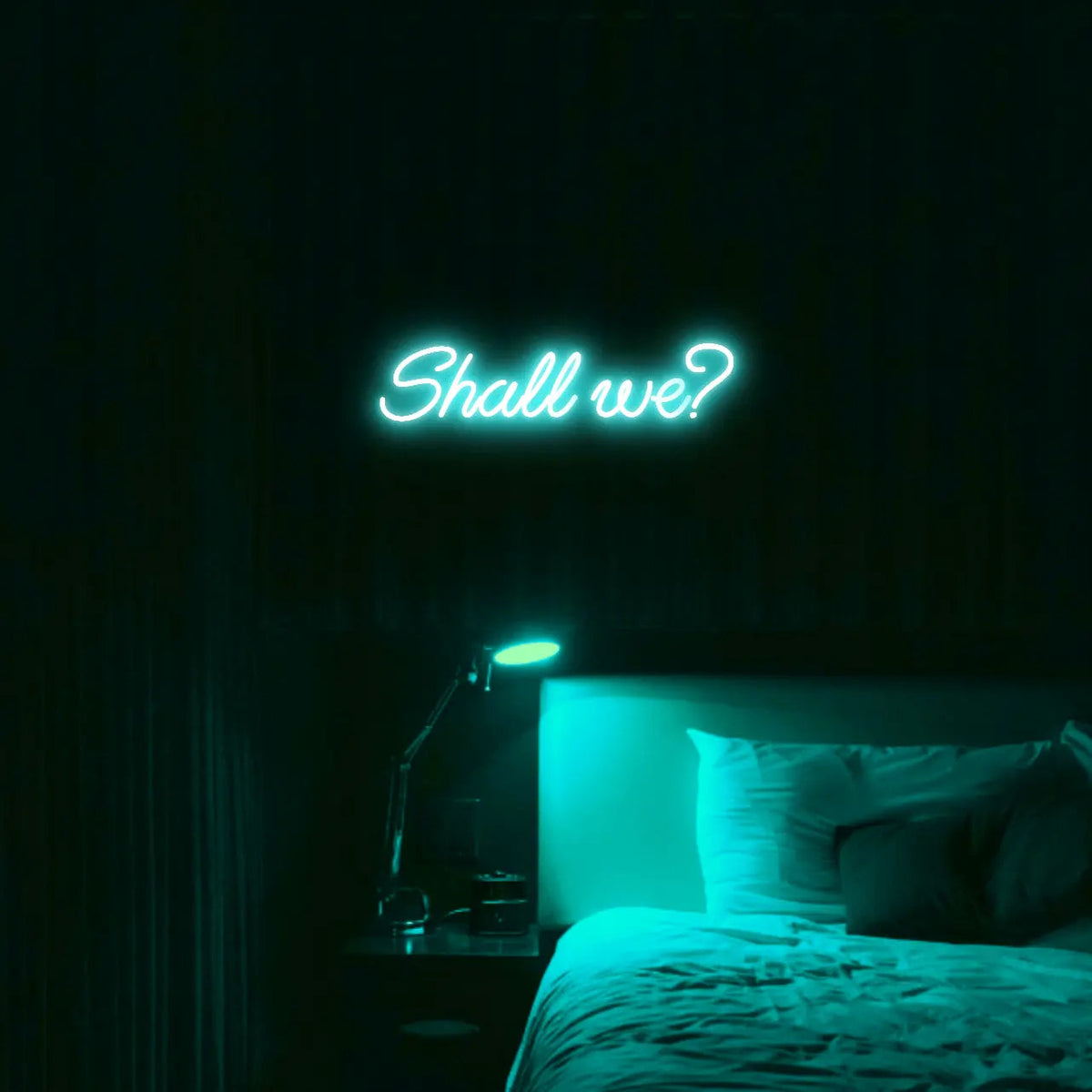 Shall we? LED Neon Light Sign in turquoise, featuring script lettering illuminated above a bed.