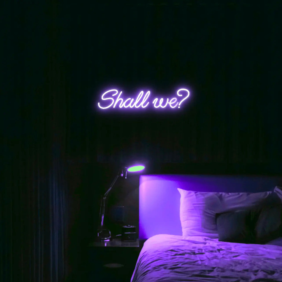 Shall we? LED Neon Light Sign in purple, featuring script lettering illuminated above a bed.