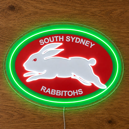 South Sydney Rabbitohs Neon Sign, featuring illuminated team logo on a wooden surface.