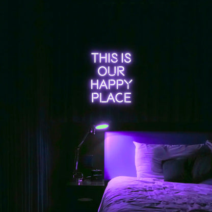 This is our happy place LED Neon Light Sign in purple, featuring stacked block lettering illuminated above a bed.