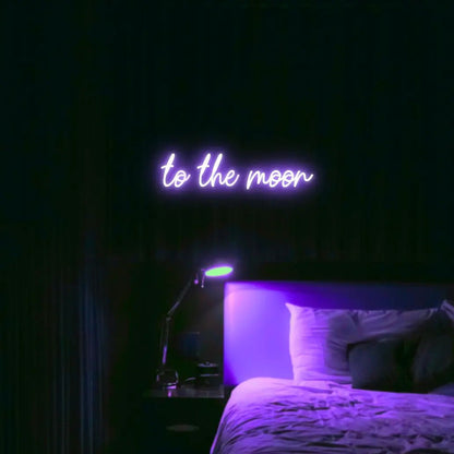 To The Moon LED Neon Light Sign in purple, featuring script lettering illuminated above a bed in a dark bedroom.
